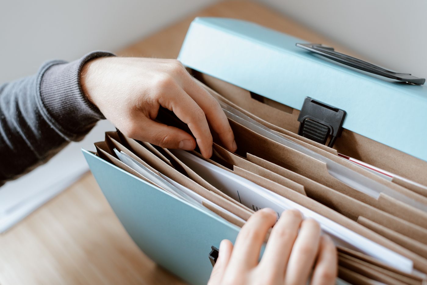 Hands organising records in a document folder